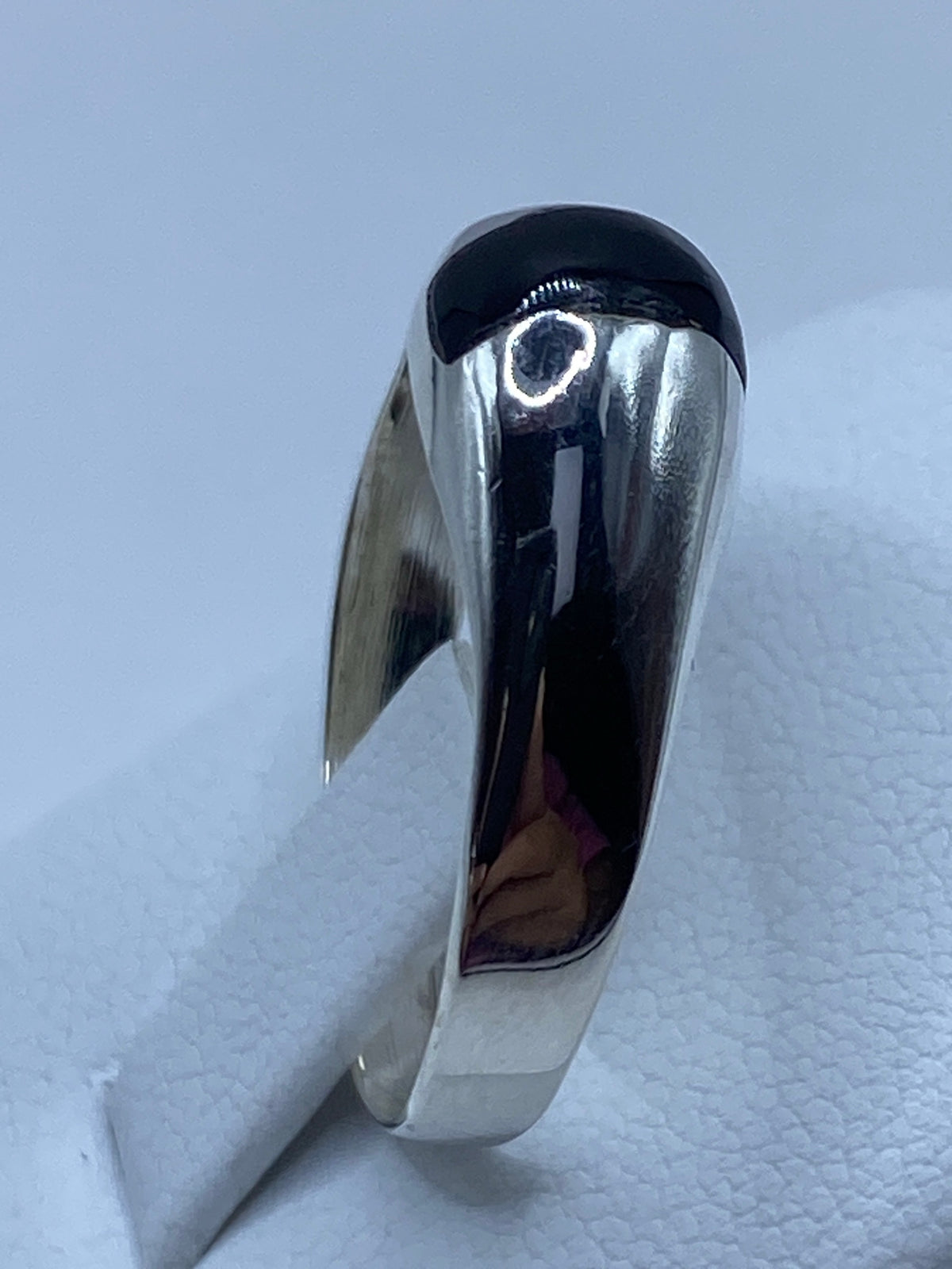 Anillo en la mano mostrando el contraste entre la plata y el ónix negro