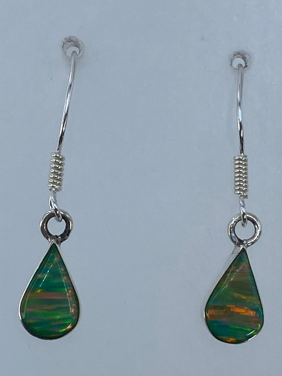 Detalle del engaste a mano y la piedra multicolor de los aretes de Taxco