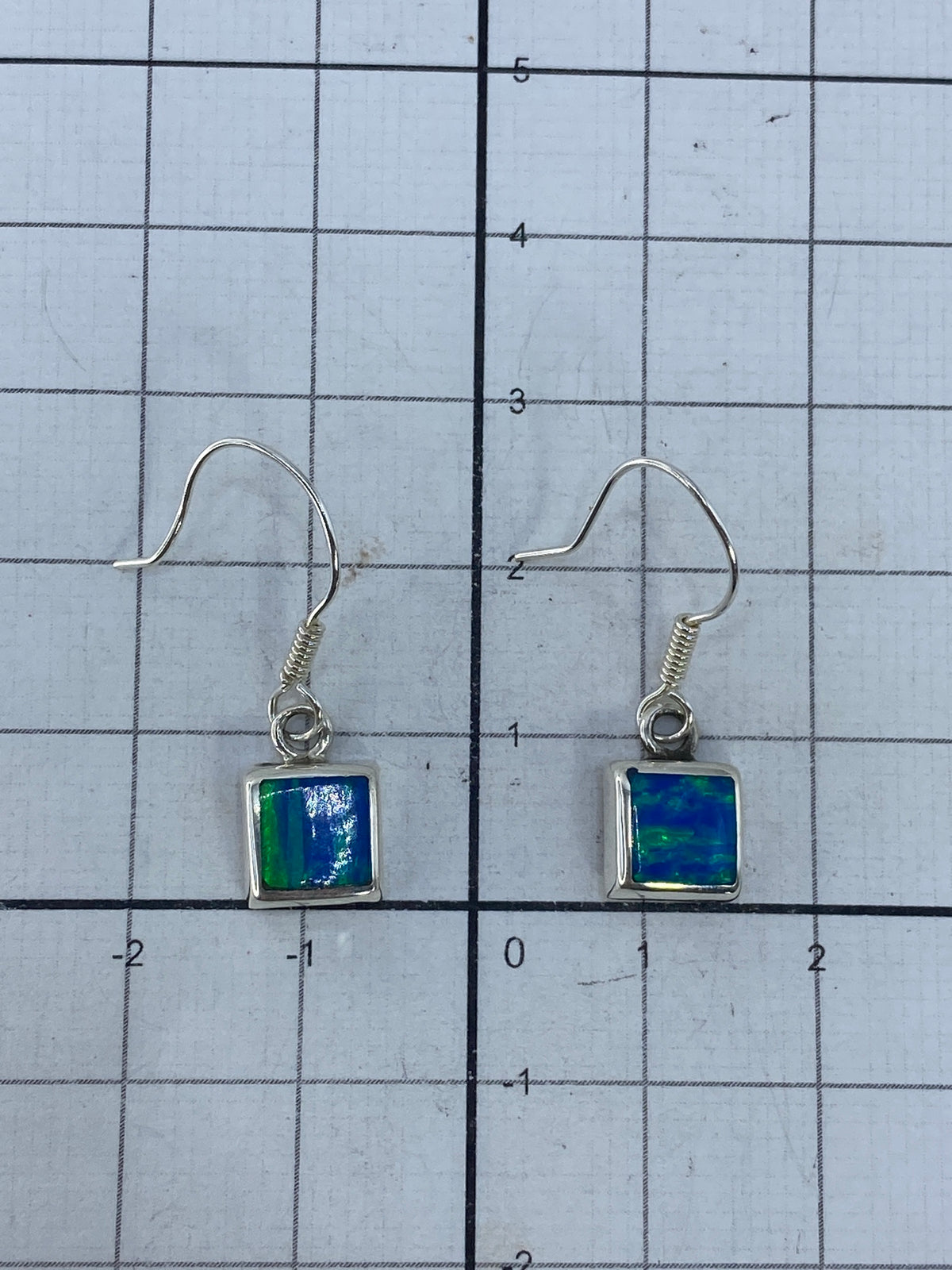 Aretes de 2.7 cm sobre escala de centímetros, mostrando el tamaño compacto