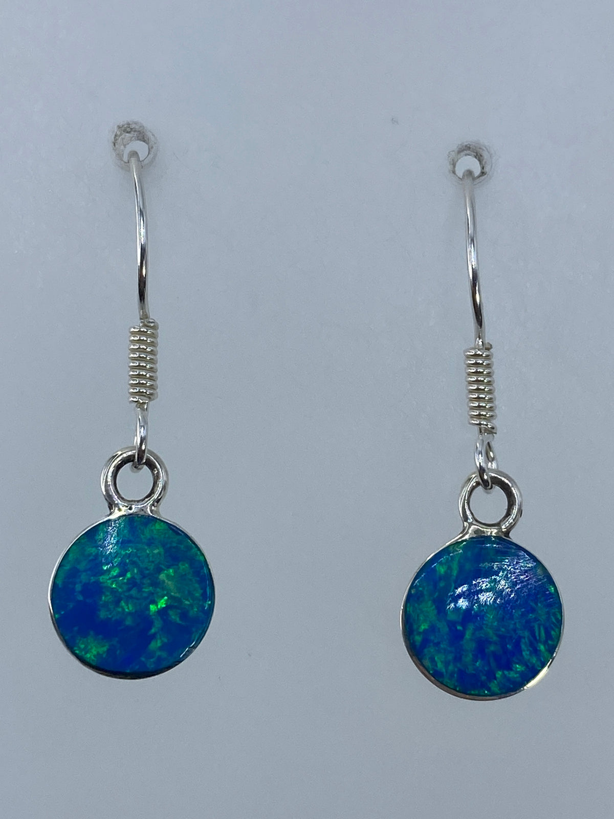 Aretes sobre regla de medición mostrando los 2.7 cm de largo