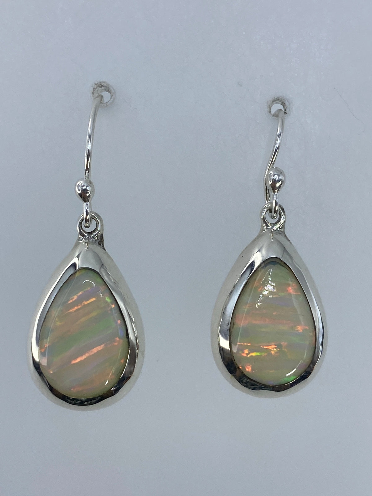 Par de aretes de plata con ópalo de fuego multicolor en ganchos de plata