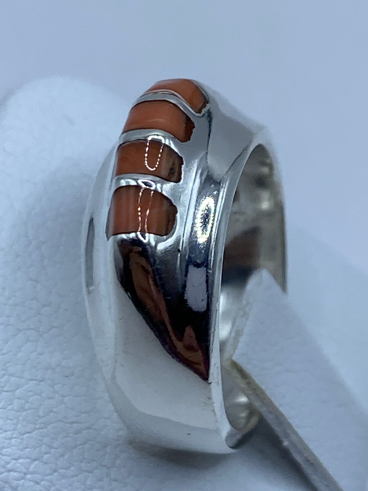 Anillo de coral y plata colocado en dedo, demostrando el tamaño real de las piedras