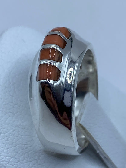 Anillo de coral y plata colocado en dedo, demostrando el tamaño real de las piedras