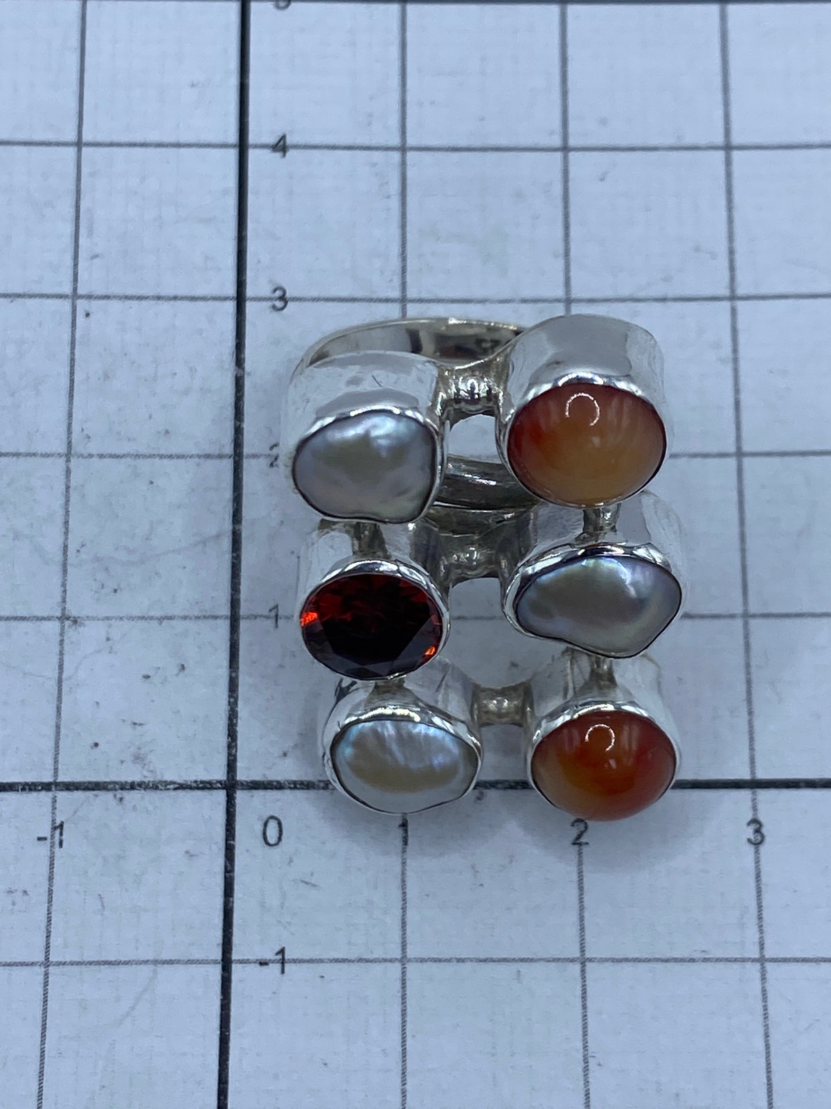 Anillo sobre fondo oscuro destacando el brillo de la perla y la circonia