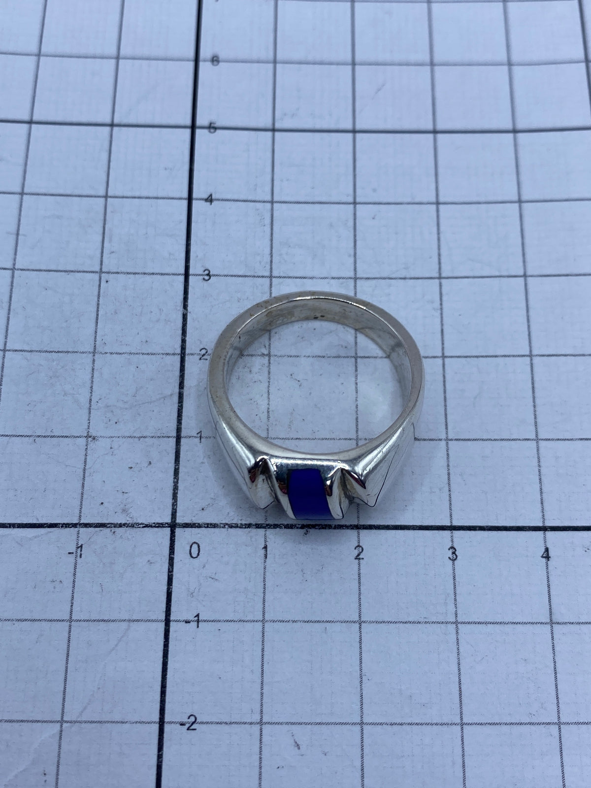 Anillo sobre fondo gris mostrando el Quinto 925 en el interior