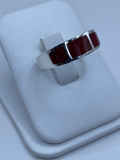 Vista lateral del anillo de plata con coral rojo mostrando el Quinto 925