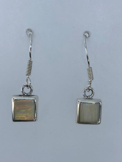 Aretes de plata con ópalo de fuego multicolor mostrando tonos naranja, rojo y amarillo