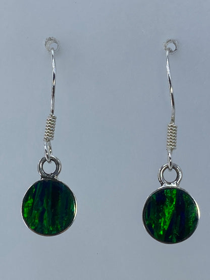 Par de aretes de plata con ópalo de fuego verde sobre fondo blanco