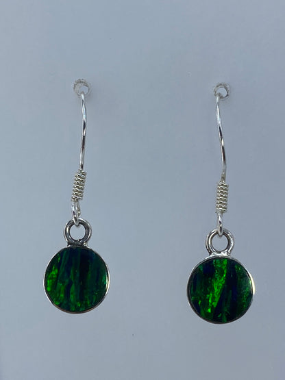 Detalle de arete de plata con piedra de ópalo de fuego color verde