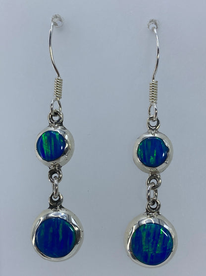 Aretes de plata con ópalo de fuego verde olivo, destellos visibles en la piedra engastada
