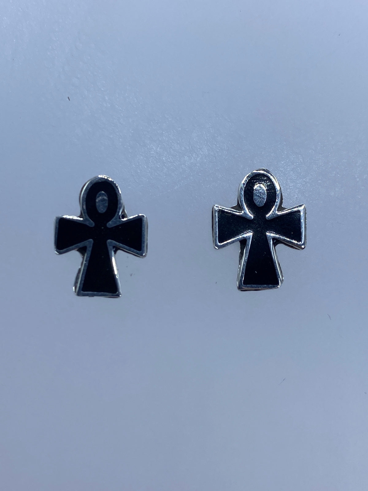 Par de aretes de cruz de plata 925 con esmalte negro sobre fondo blanco
