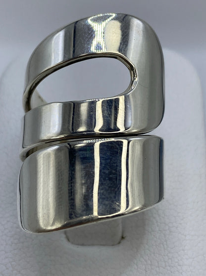 Anillo de plata calado con geometría escultórica en la mano de una mujer