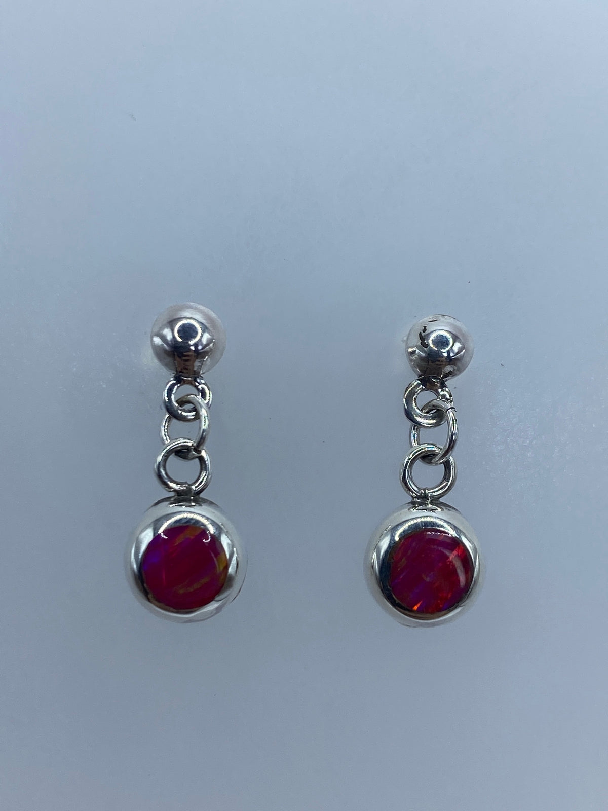 Par de aretes de plata con ópalo de fuego rosa, 2 cm, sobre fondo gris