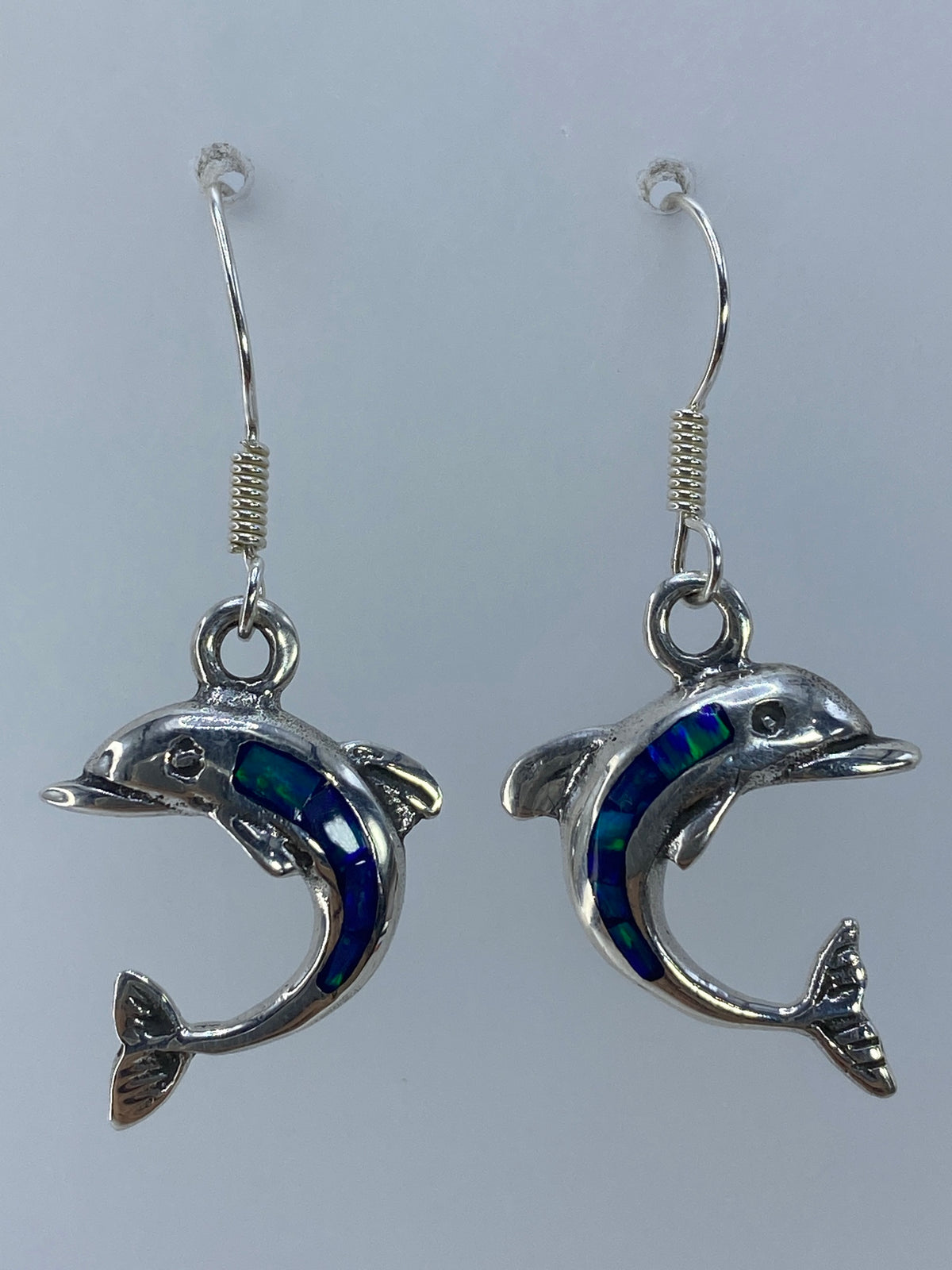 Aretes delfín de plata 925 con ópalo de fuego verde olivo, largos 3.8 cm, junto a una regla de medida