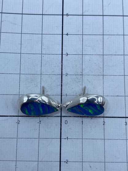 Aretes sobre fondo gris mostrando el brillo del ópalo azul y el Quinto 925