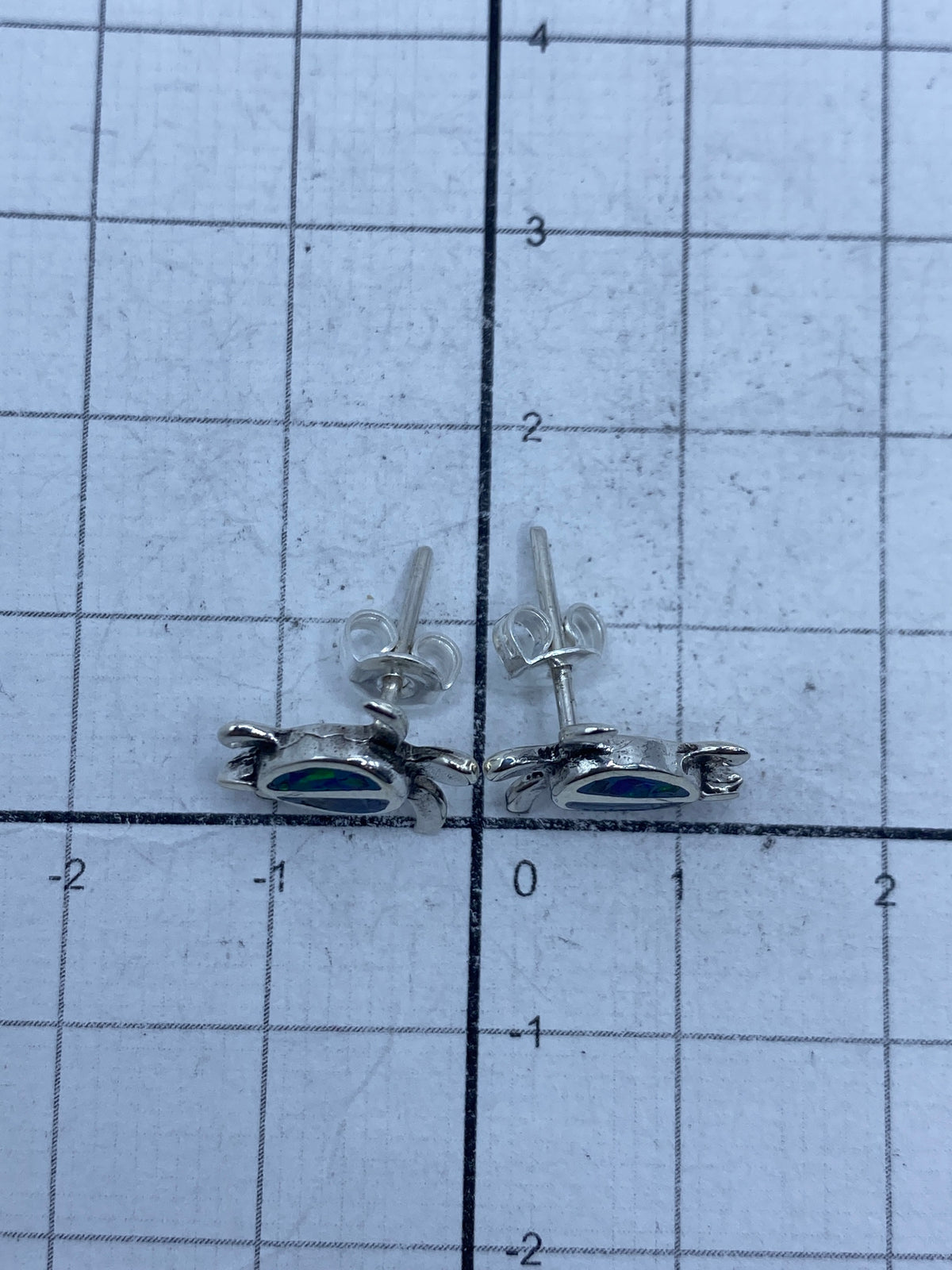 Aretes de Taxco de 1.2 cm medidos en regla, mostrando tamaño pequeño y delicado