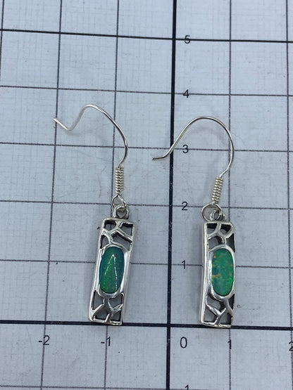 Aretes sobre fondo neutro con gancho de plata visible