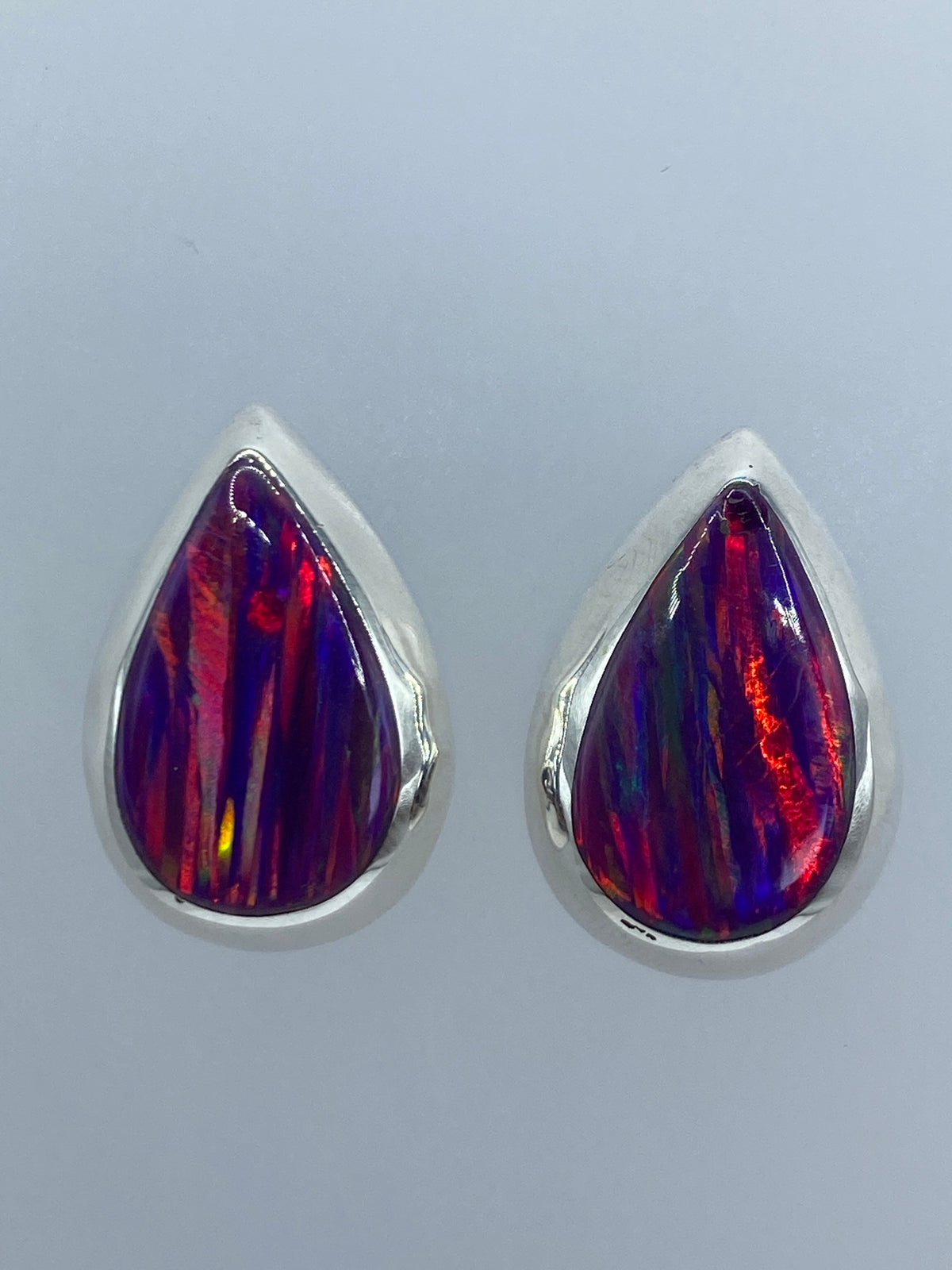 Detalle lateral de un arete mostrando la intensidad del color morado y los reflejos de fuego