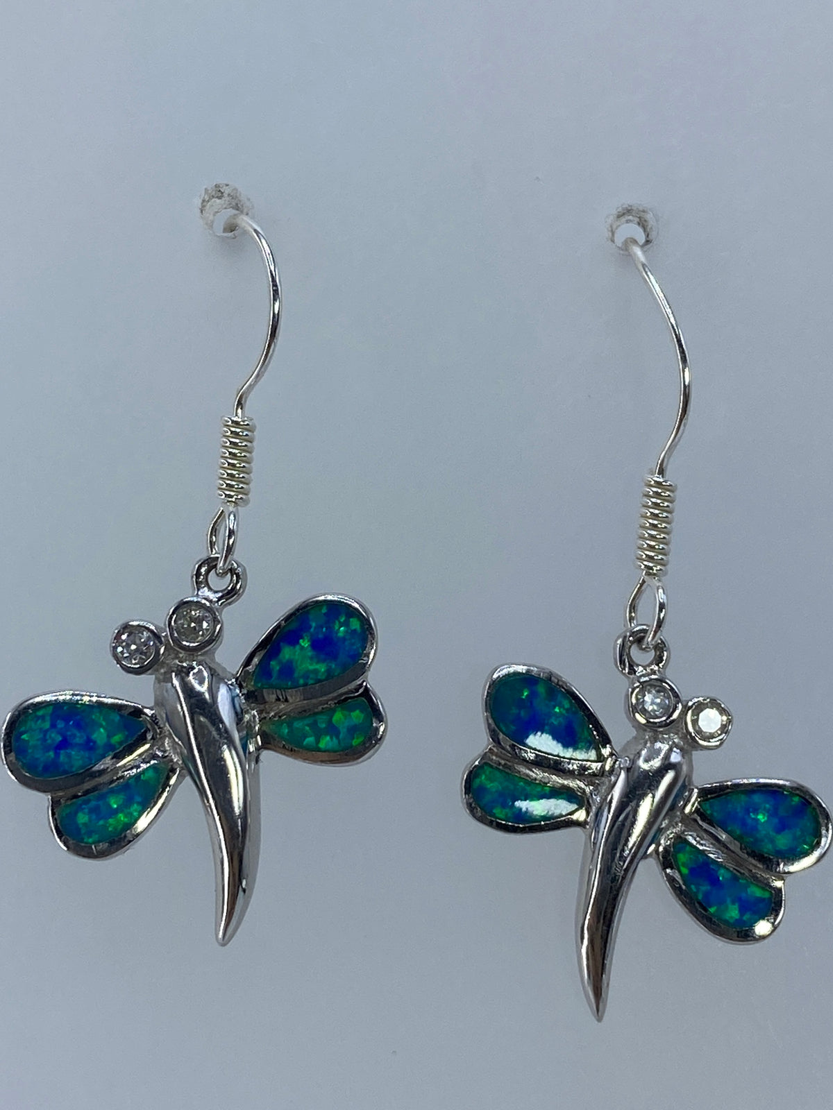 Aretes colgando mostrando el largo de 3.3 cm y el movimiento de la luz en el ópalo