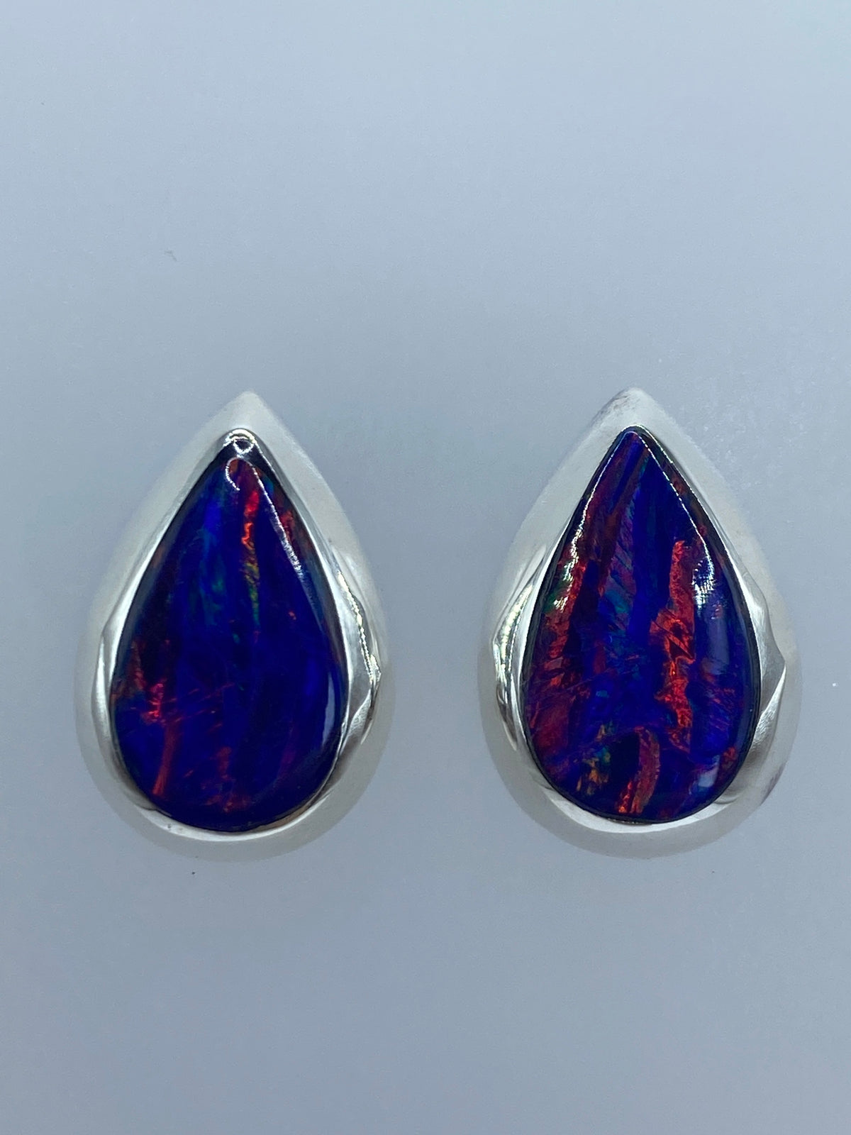 Detalle del ópalo de fuego con iridiscencia multicolor en ambos aretes