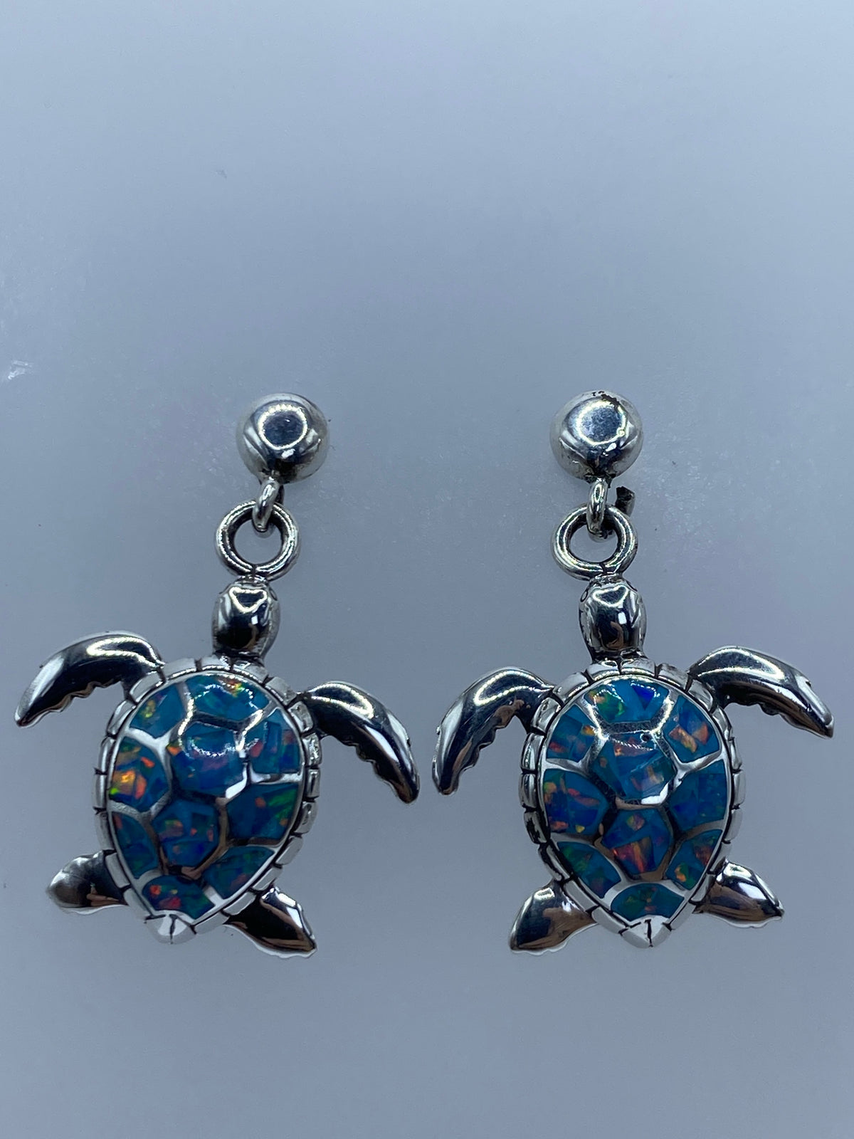 Detalle del ópalo de fuego con destellos de color azul, verde y coral bajo la luz