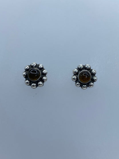 Detalle del engaste a mano del ámbar en la esfera de plata granulada