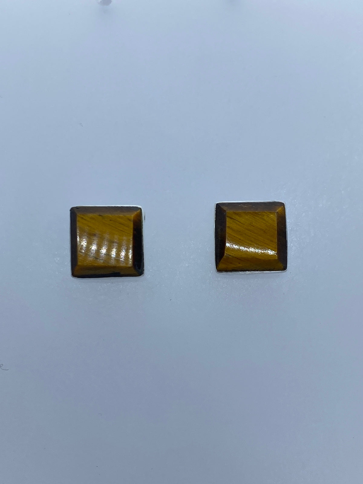 Aretes con ojo de tigre mostrando el brillo y reflejos ondulantes de la piedra