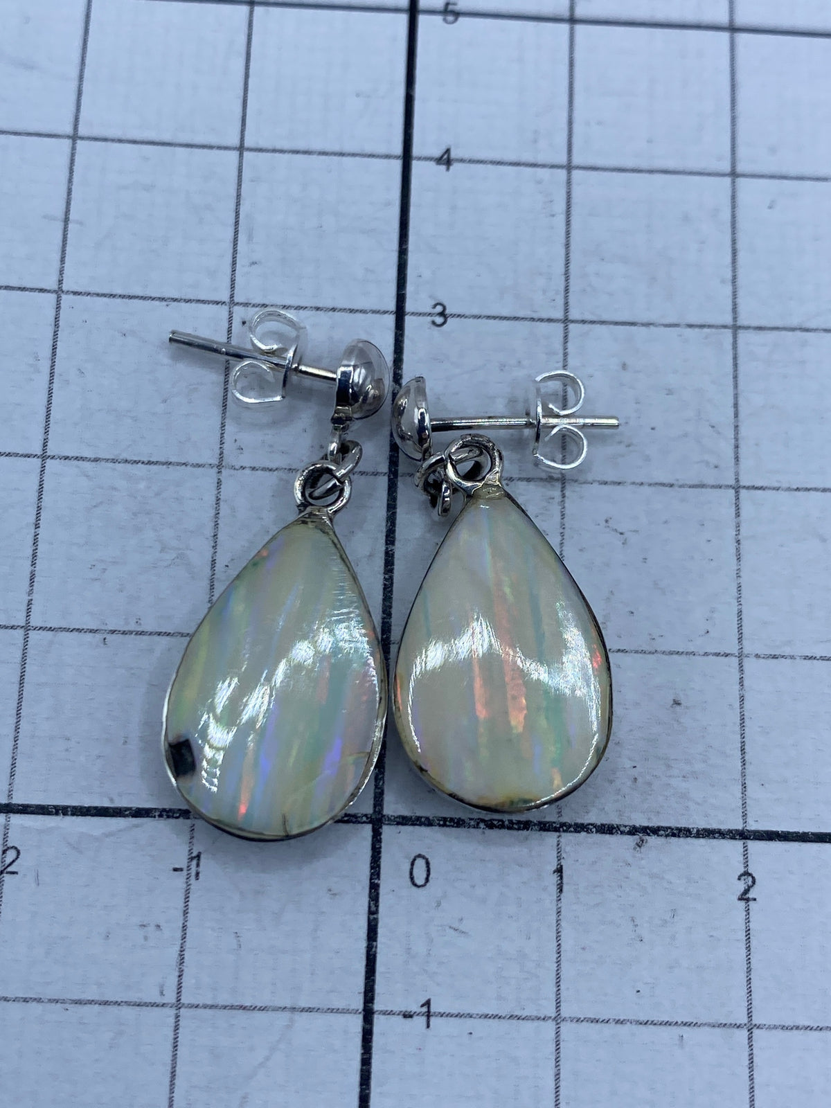 Aretes sobre balanza mostrando peso de 3.7 gramos y Quinto 925