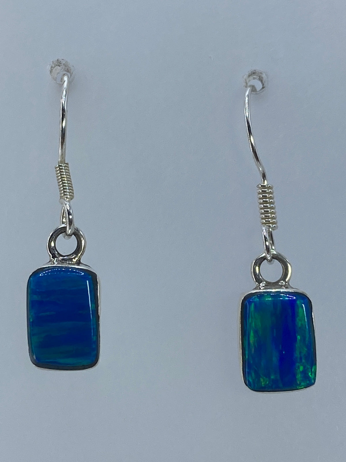 Aretes de plata con ópalo de fuego verde olivo, el par colgando