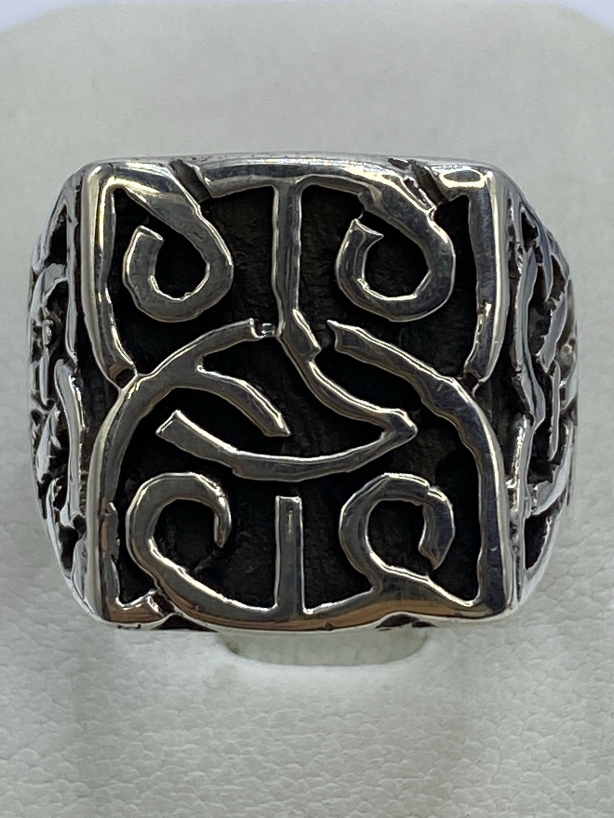 Anillo de plata calado con diseño geométrico abierto sobre fondo blanco