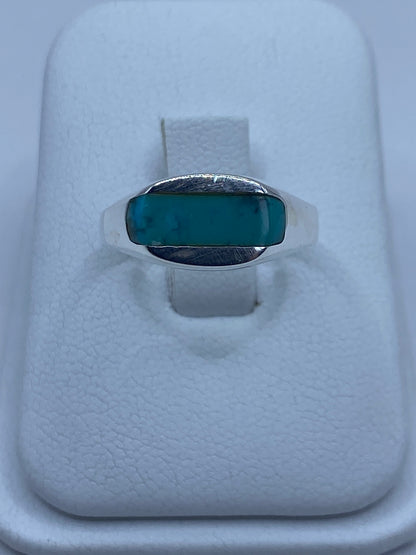 Anillo de plata 925 con turquesa azul cielo engastada, visto desde arriba sobre estuche blanco