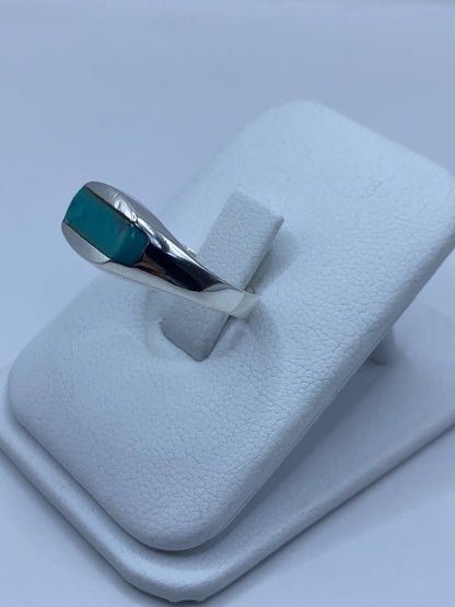Detalle lateral del anillo mostrando el engaste de turquesa y la banda de plata pulida