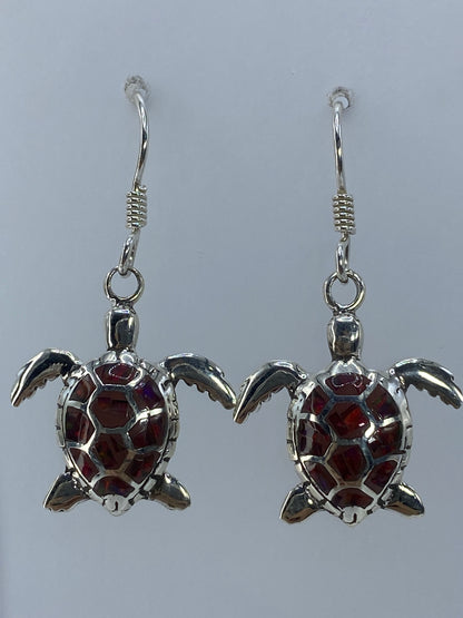 Aretes largos de plata con ópalo de fuego multicolor, colgando en posición frontal