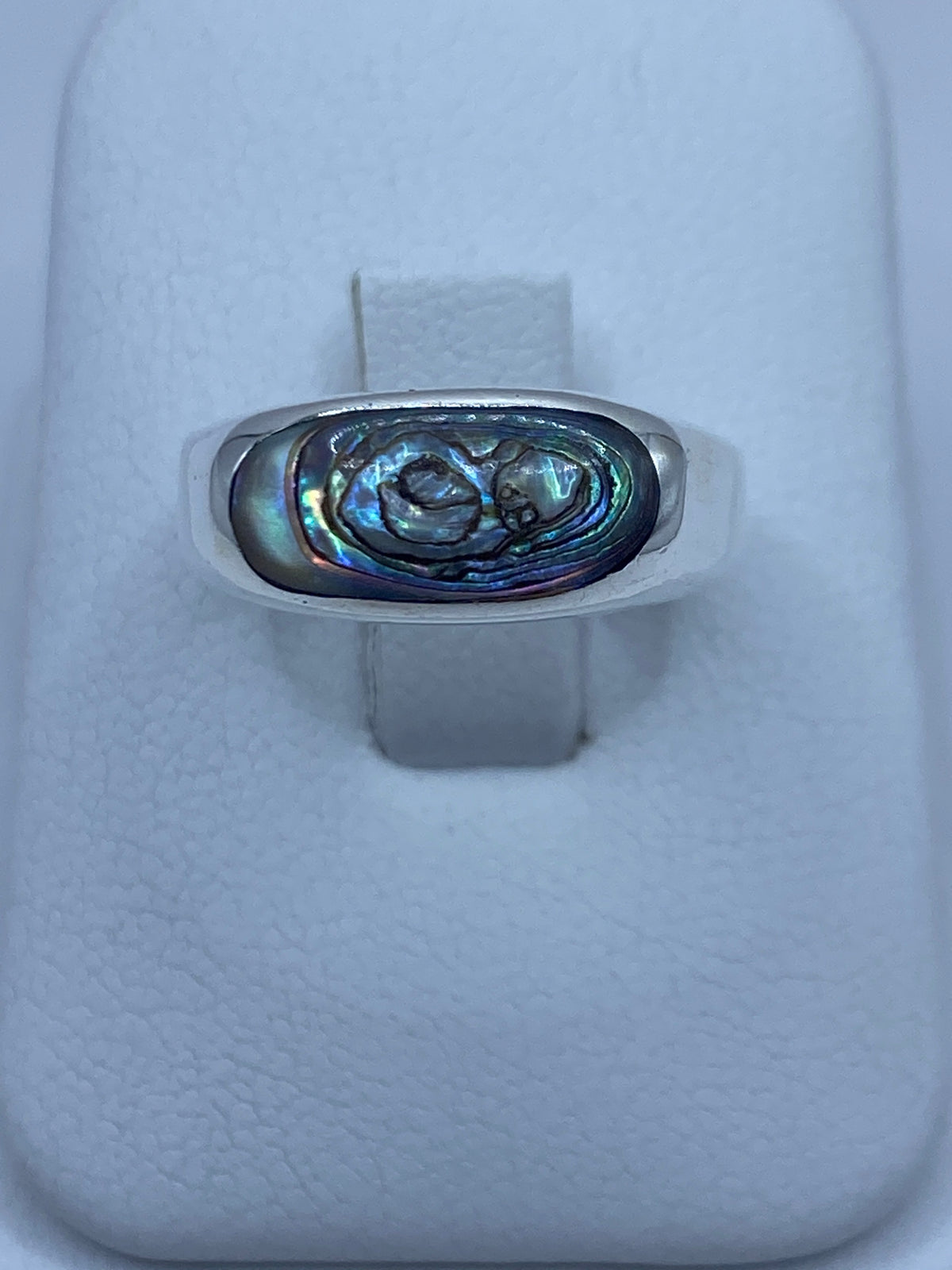 Anillo de plata con concha de abulón iridiscente azul-verde en vista de frente