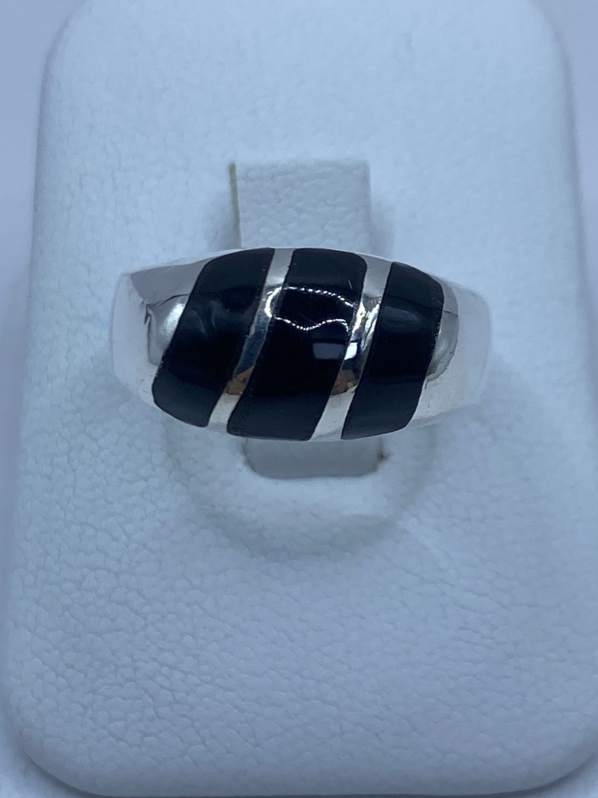 Anillo de plata con ónix negro profundo visto desde arriba en caja blanca