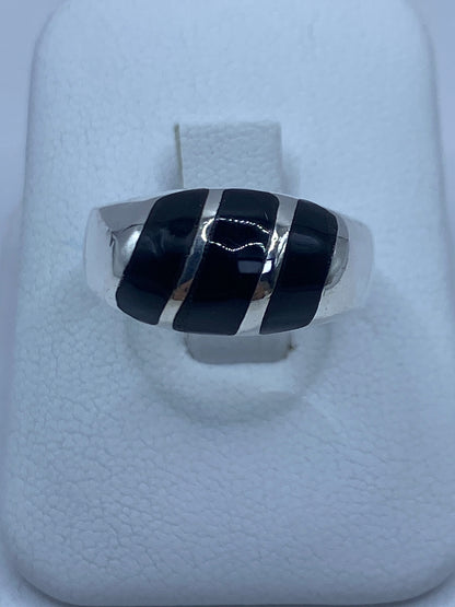 Anillo de plata con ónix negro profundo visto desde arriba en caja blanca