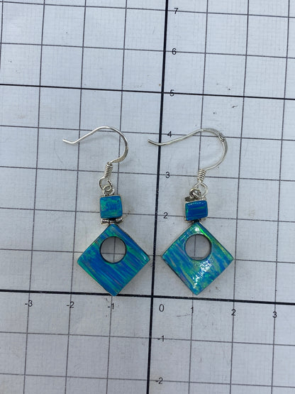 Aretes sobre fondo blanco con hallmark 950 visible en la plata
