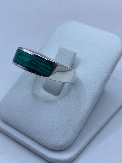 Detalle lateral del anillo mostrando el engaste a mano de la malaquita y las vetas naturales