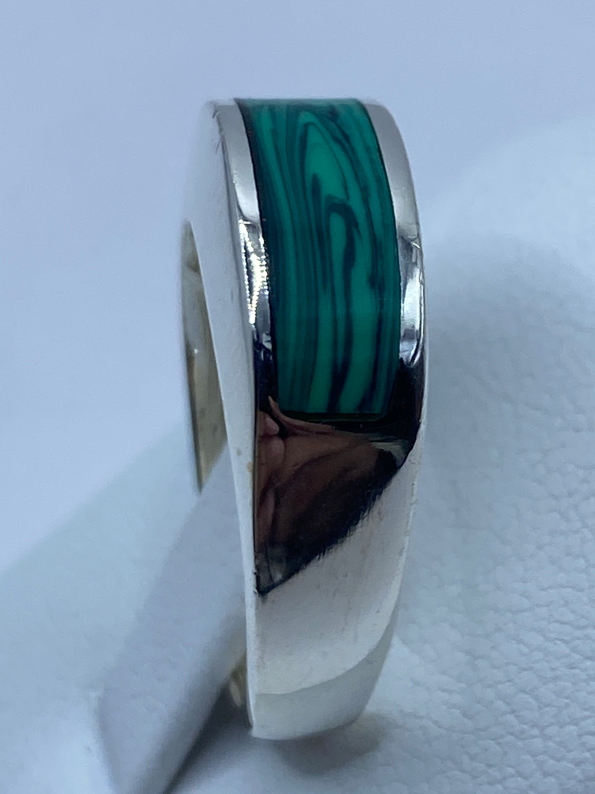 Anillo puesto en el dedo mostrando cómo luce la malaquita verde con la plata