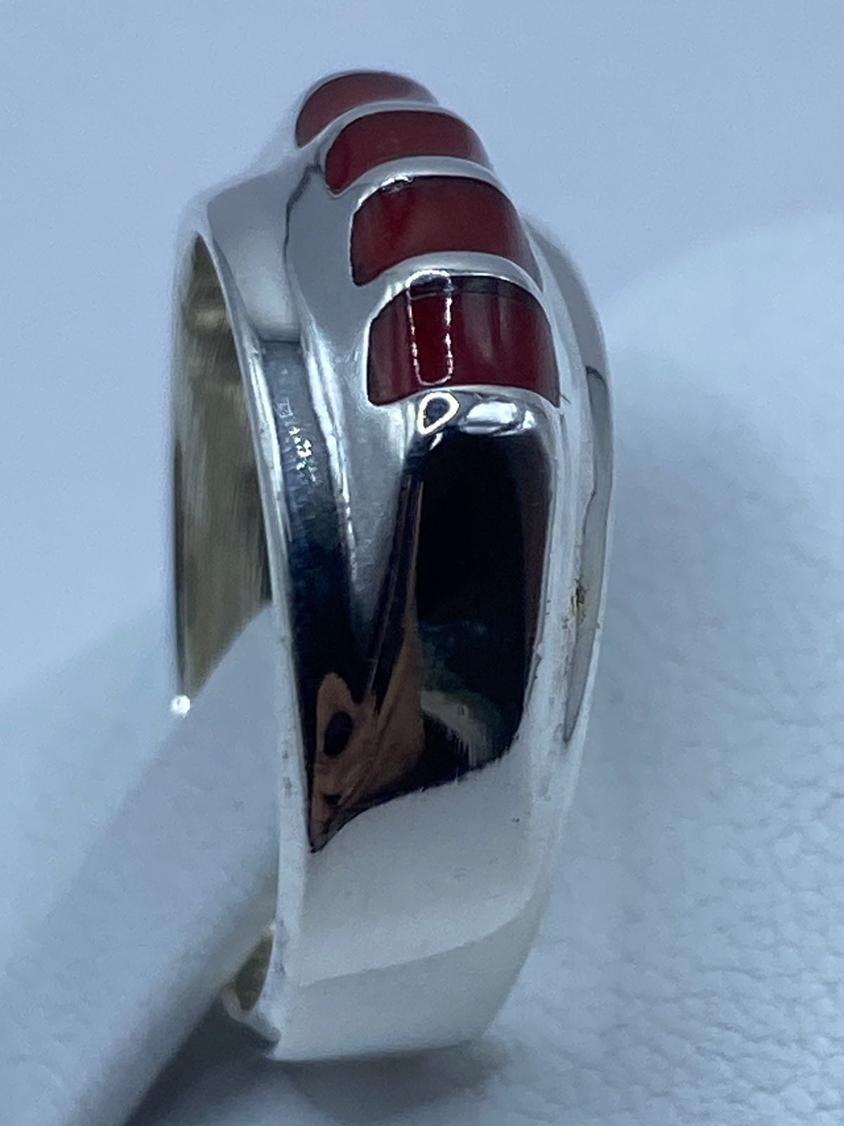 Vista lateral del anillo de plata con coral, detalle del engaste a mano