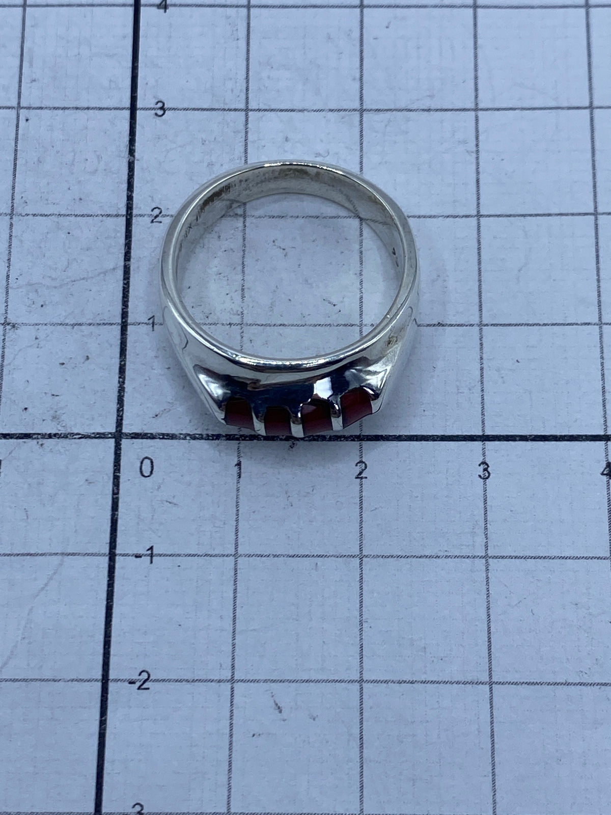 Anillo en escala métrica sobre superficie clara, mostrando el tamaño y el Quinto 925