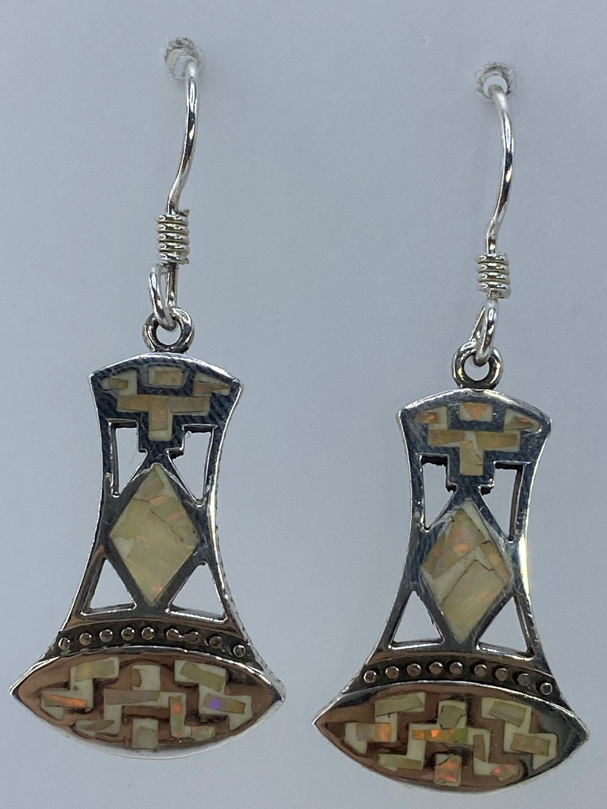 Aretes colgando mostrando el brillo multicolor del ópalo de fuego