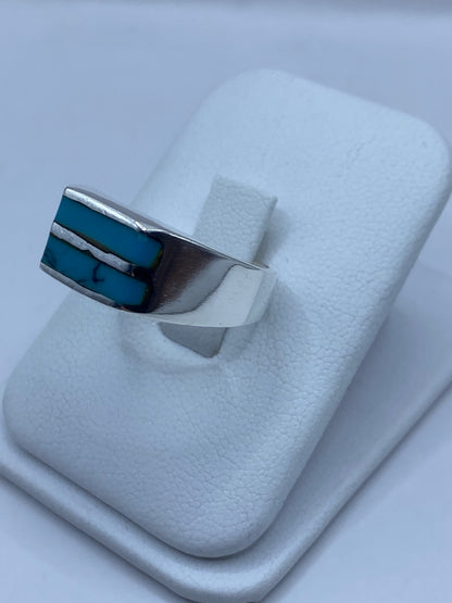 Anillo en mano mostrando la turquesa azul y el pulido plateado en uso