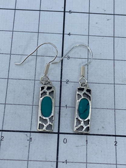 Aretes sobre regla de medición mostrando 3.7 cm de largo