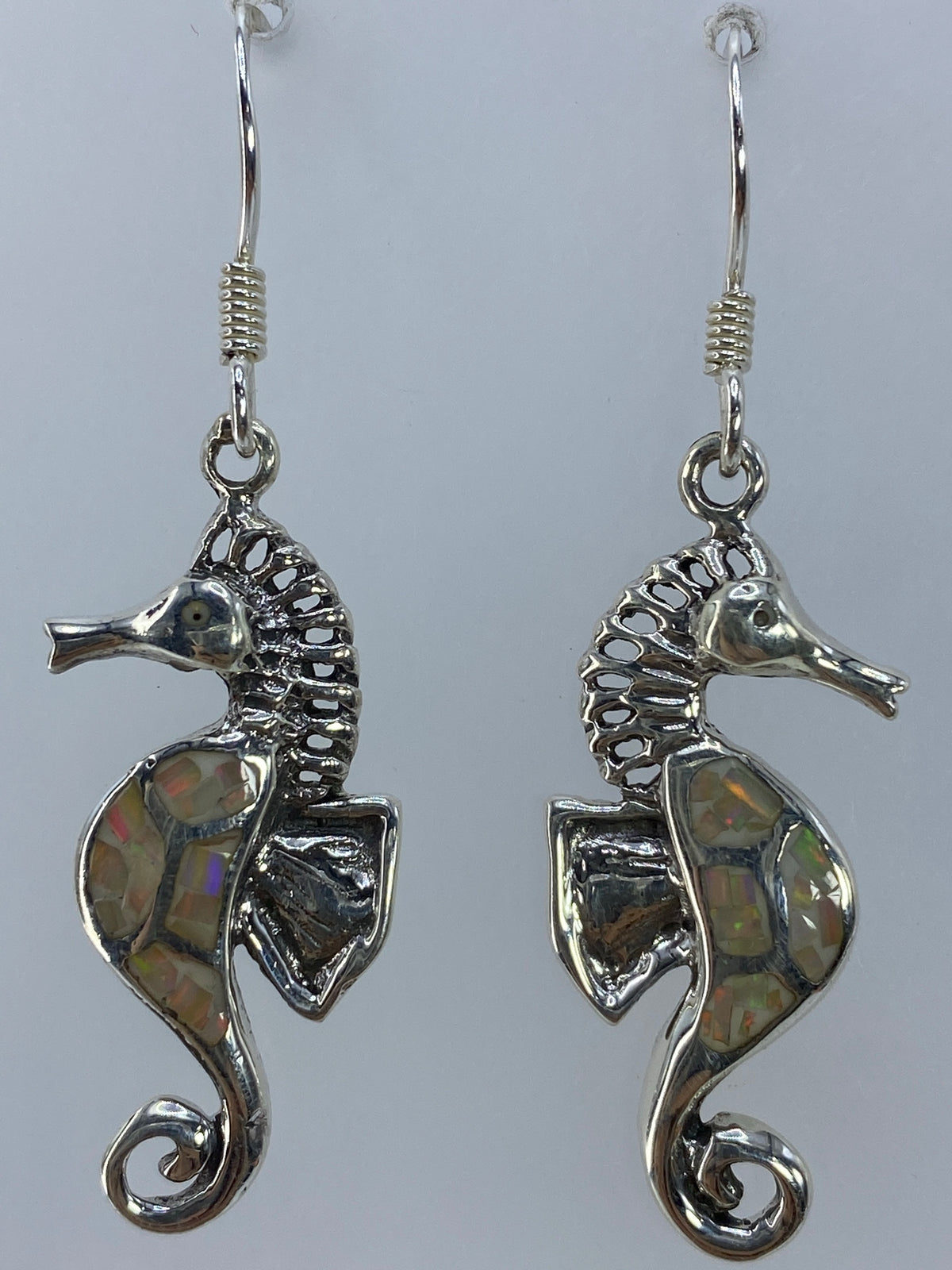 Aretes caballito de mar sobre fondo neutro mostrando el Quinto 950