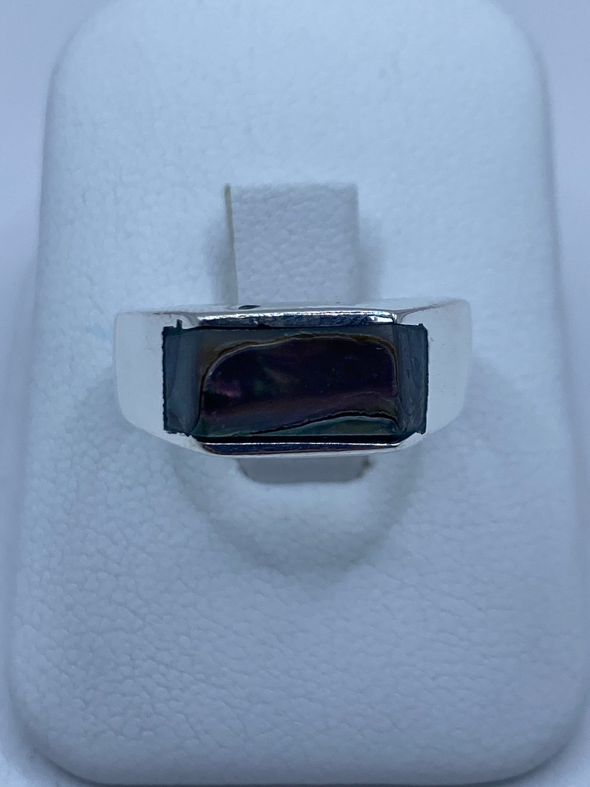 Anillo de plata 925 con concha de abulón iridiscente en la mano