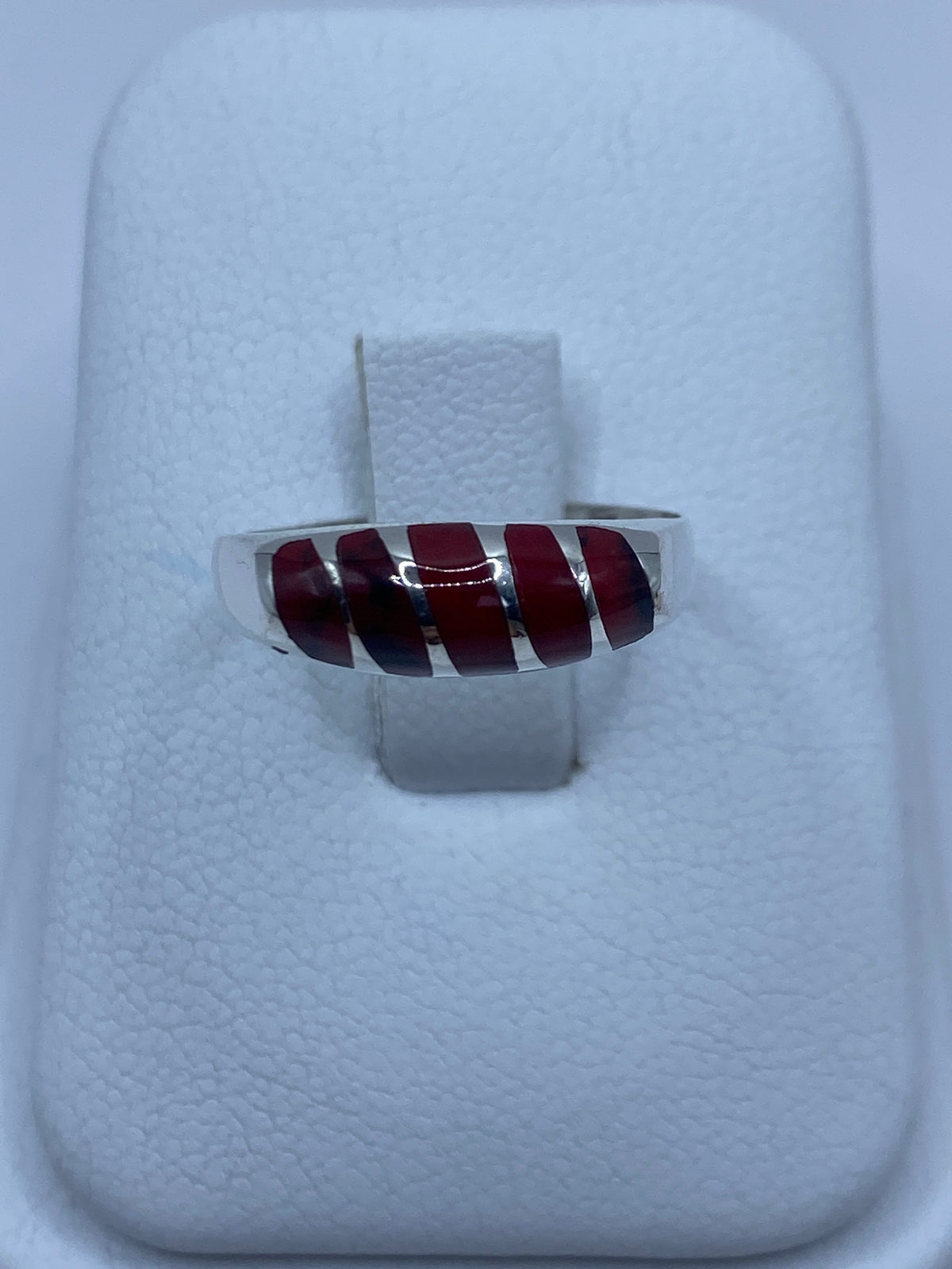 Anillo de plata 950 con coral rojo engastado en la mano de una persona