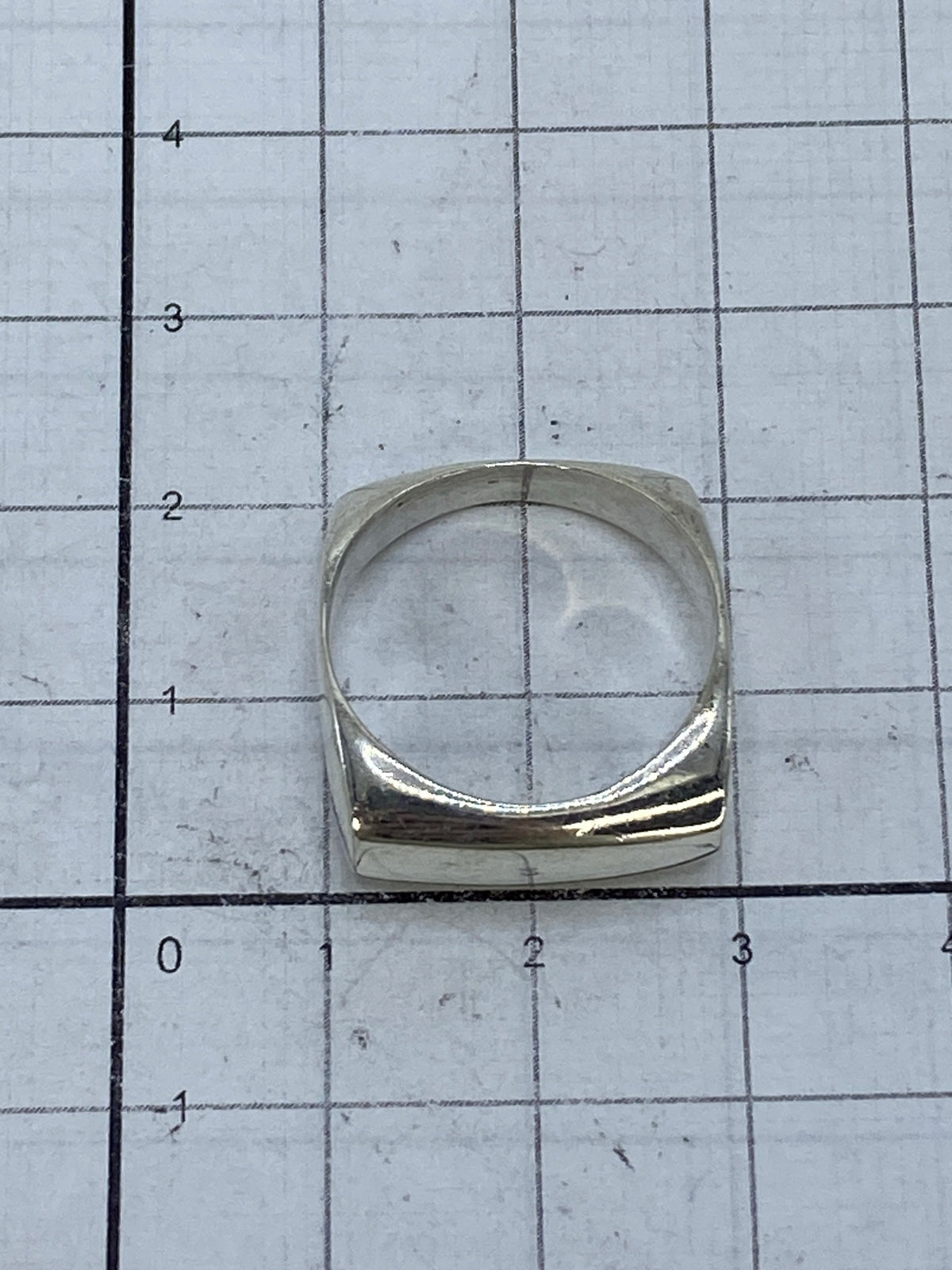Anillo puesto en dedo masculino, mostrando el acabado pulido y el corte preciso