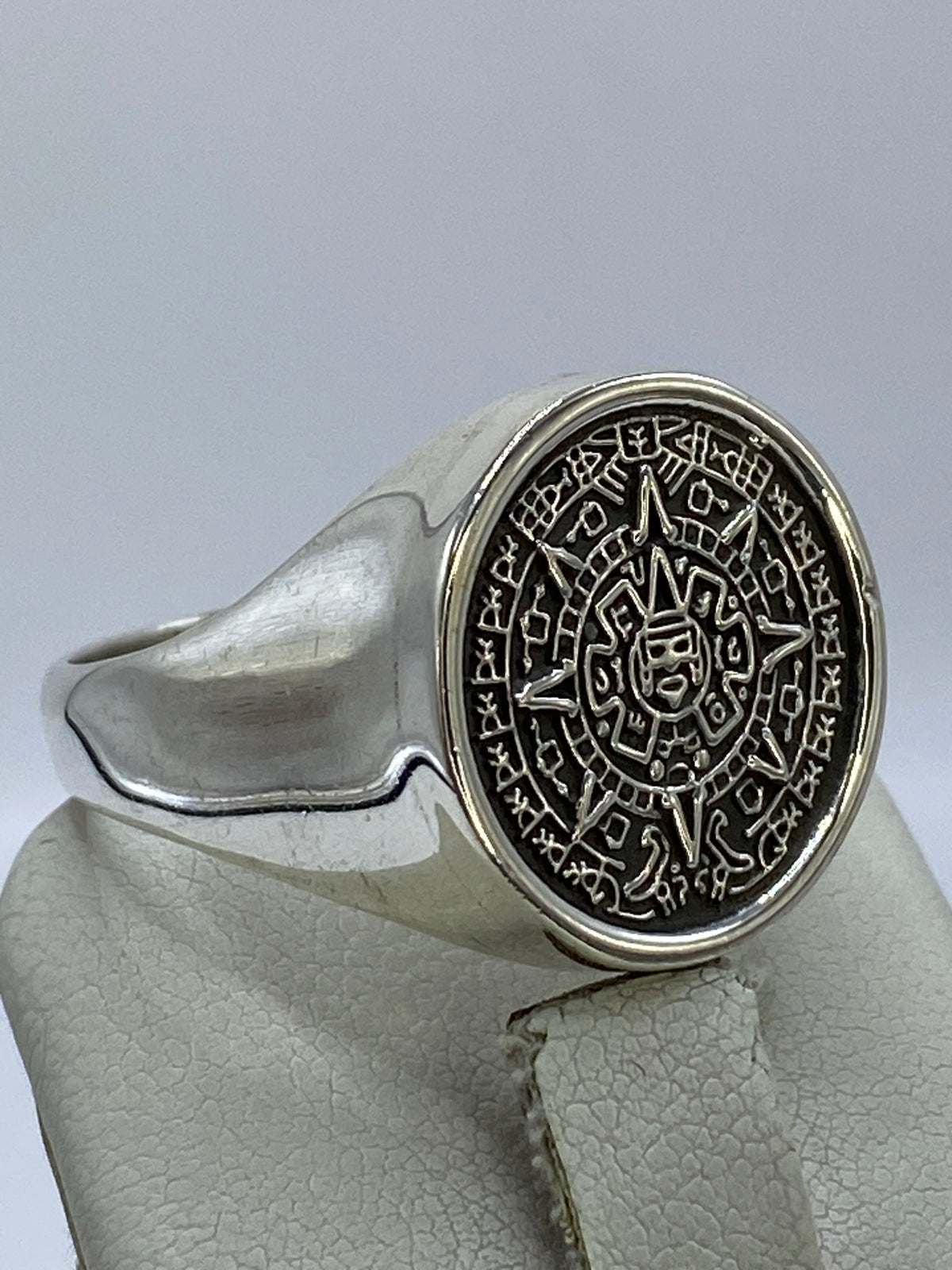 Anillo Calendario Azteca en la mano de un hombre, mostrando el peso y detalle
