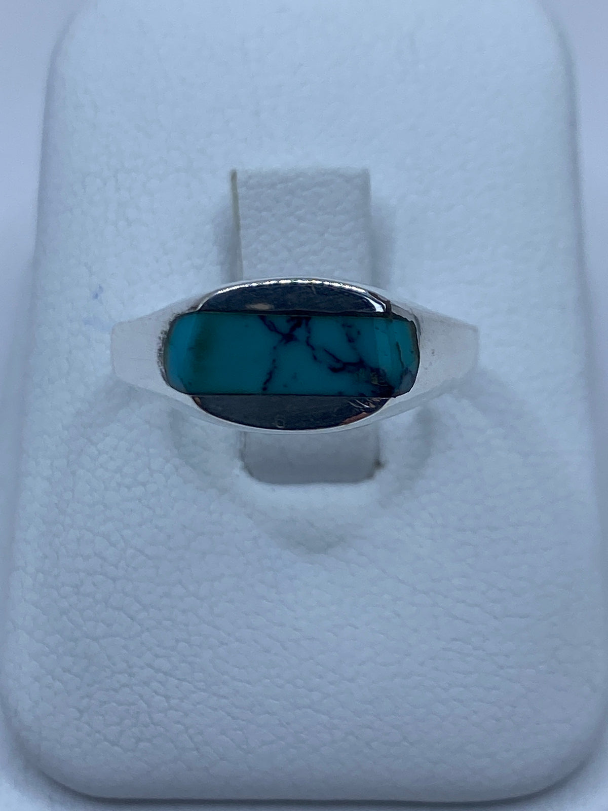 Anillo de plata con turquesa azul cielo engastada en la mano de una mujer